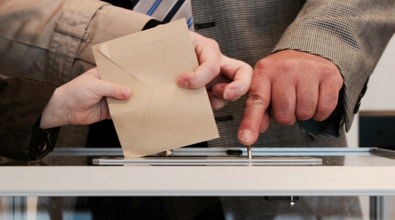 Un électeur glissant son bulletin de vote dans les urnes.